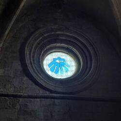 Ein Rundfenster dient zugleich als Wegmarkierung für den vorbeilaufenden Jakobsweg.