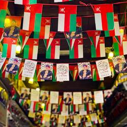Omani flags and banners featuring the current sultan .. Mutrah Souq — Muscat, Oman.