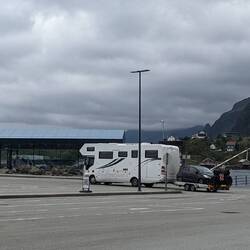 Wohnmobil/LKW mit Anhänger auf dem ein Auto und zwei Fahrräder/Motorrad transportiert werden