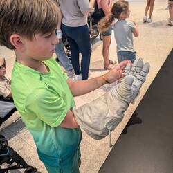 Trying out an astronaut's glove at Air & Space.