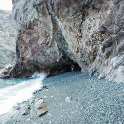 Christian erkundet eine kleine Höhle am Kiesstrand