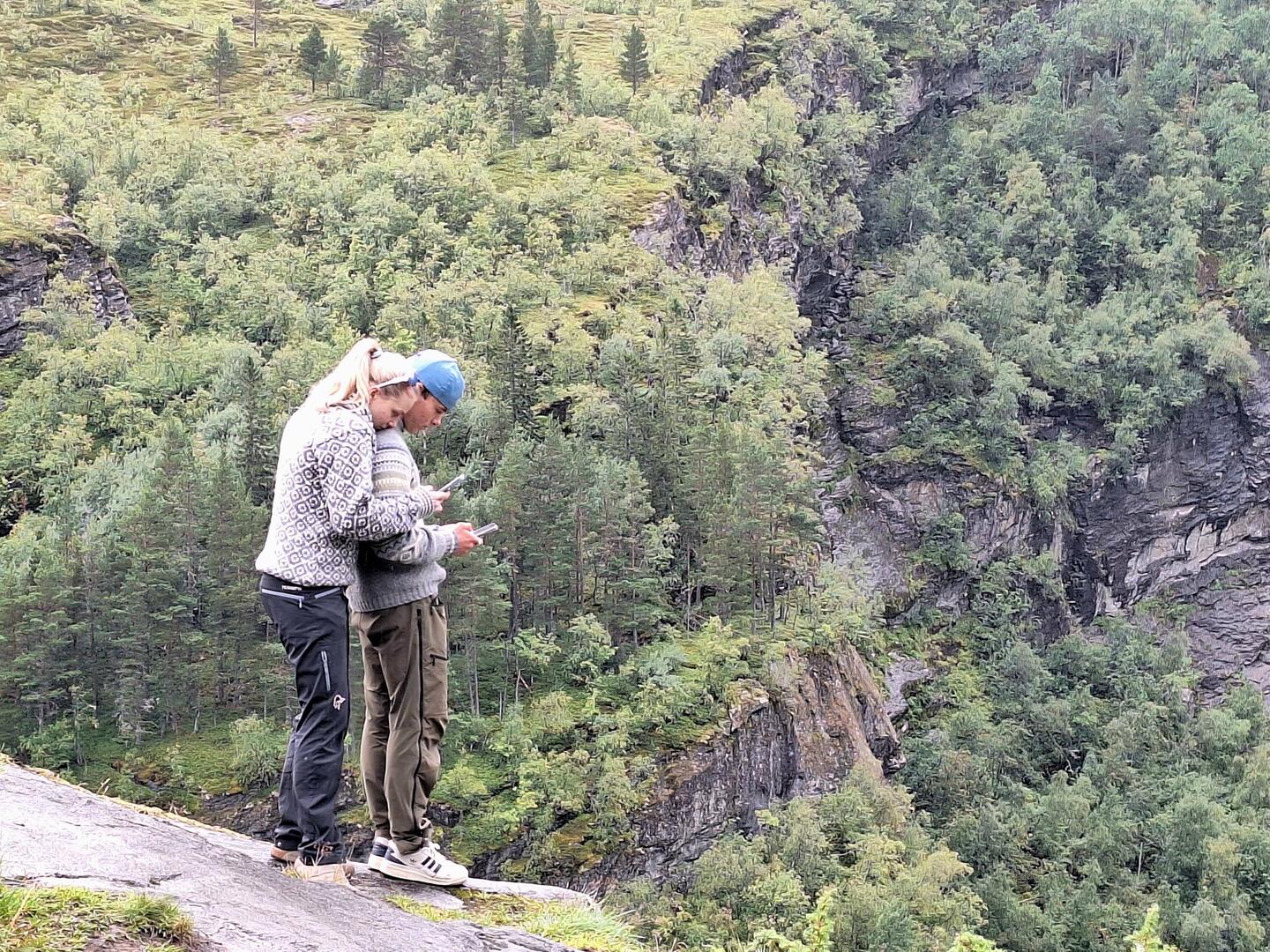 A metaphor for the youth of today -- on the precipice but looking at their phones