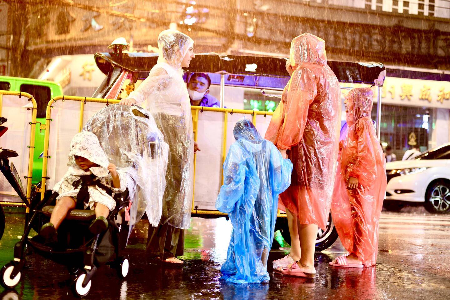 Sobald es anfängt zu regnen, starten die Regenbekleidungs-Verkäuferinnen erfolgreich ihr Business.
