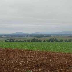 Eine hügelige Landschaft mit weiten Feldern