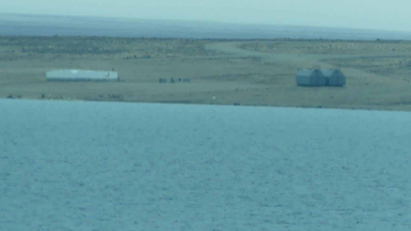 picture at a distance of an old cold war radar station with an aircraftrunway
