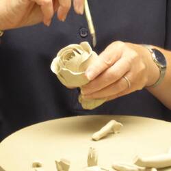 Handgeformte Blütenblätter werden mit Porzellanpaste zusammengeklebt.