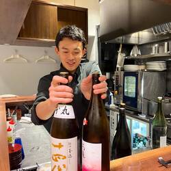 Young chef serving us Saki to taste