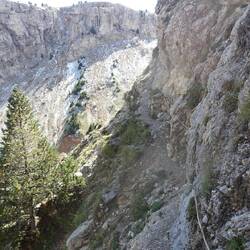 Bergab geht es direkt an der Felswand entlang