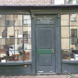 In the yard; the Enid Porter Building is dedicated to a former curator