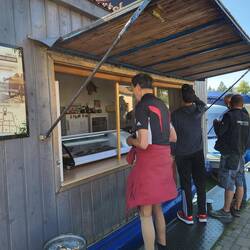 Der Tanzwolf bekommt ein Fischbrötchen.