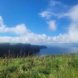 The Cliffs of Moher by land on a warm sunny day.