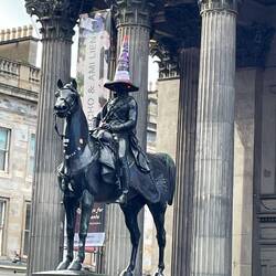 Statue of Wellington adorned with traffic cone