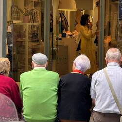 Sweet couples enjoying each other's company on a bench outside of a shop in one of the plazas.