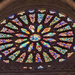 Light shines through the rose window as the sun sets