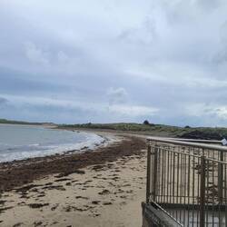 Very long beach and sand dunes in the distance. Even though it was rainy people were walking dogs.