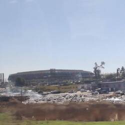 Fußball Stadion der WM 2010, davor als schöner Kontrast, die Blechhütten der Bewohner Sowetos