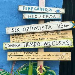 It says, "Pilgrims, remember to be optimistic. 8.5 km. "