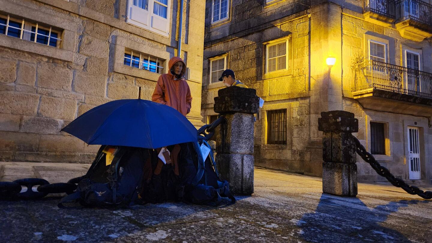 Protecting our bags from potential rain, waiting for the bus