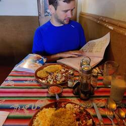 Andi zeigt beim Mittagessen begeistert seine Hausaufgaben