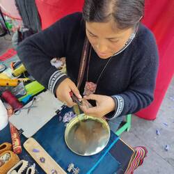 Auf einem Markt passt die Künstlerin ein Armband exakt für Tanja an