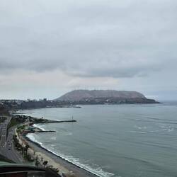 Strand, Hauptstrasse, hohe Klippe und darauf die Stadt