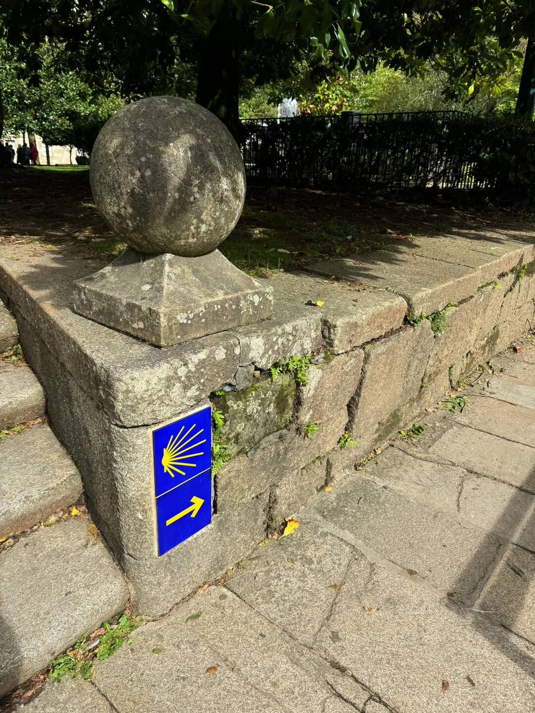 Eine gelbe Muschel auf meist blauem Grund weist den Jakobspilgern den Weg.