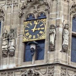 Figure under clock sticks his tongue out on the hour.