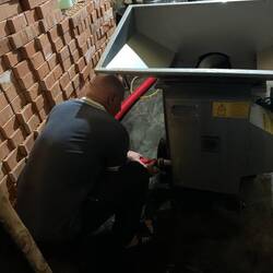 Connecting the hose to the de-stemmer to catch the juice