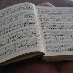 This book of sheet music was by the little couch.