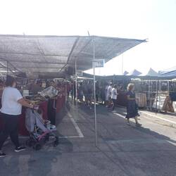 Ein Markt auf dem Weg mit Obst, Gemüse, Gebäck und viel Kleidung