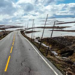 Road north with poles showing edge of road when deep snow.