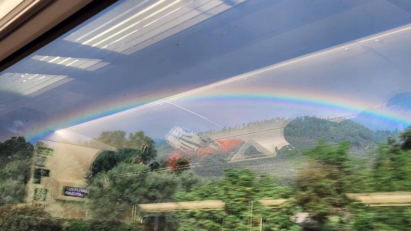 The rainbow is INSIDE, on the glass of the window.