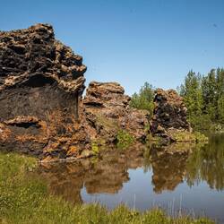 Lava Pillars at Lake Mývatn. The black dots in the sky are midges which give the lake its name.