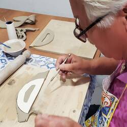 Cutting and shaping the handles for his tray