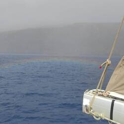 Glückliche Mahana berührt vom Regenbogen auf dem Wasser