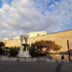 Vorne ein Kriegsdenkmal. Dahinter die Festung Calvi.
