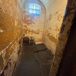 Zelle mit Matratze, Toiletteneimer und Tisch. Sonst gab es nur noch eine Bibel.