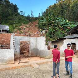 Der Sohn zeigt uns die Stelle wo beim Erdrutsch ein Teil der Familie ums Leben gekommen ist