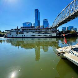 The smoke stacks bend to go under the bridge
