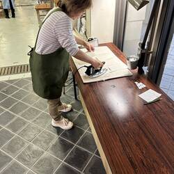 Worker irons every sheet of paper to flatten.