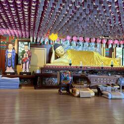 Reclining Goddess of Mercy holding Lotus flower.