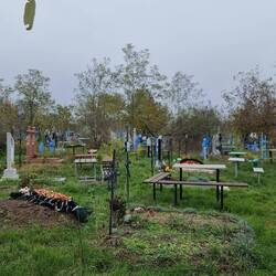 Orthodoxer Friedhof. Neben jedem Grab stehen Stühle oder Bänke und Tische