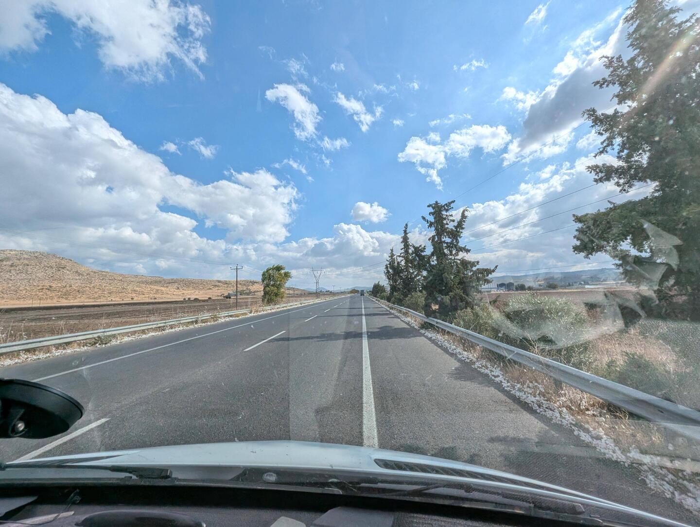 Links & rechts der Strasse liegen kleine, weisse Bommel