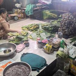 Cleaning banana leaves ready to wrap round cake