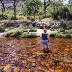 Heldere colakleurige rivier te voet overgestoken