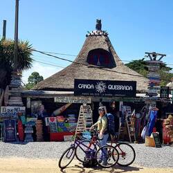 Cycling. Curiosity shop in background. La Barra.