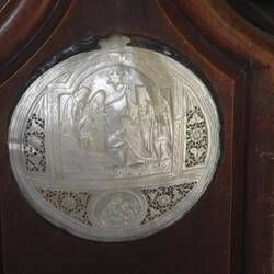 Carved mother of pearl shell on end of pew