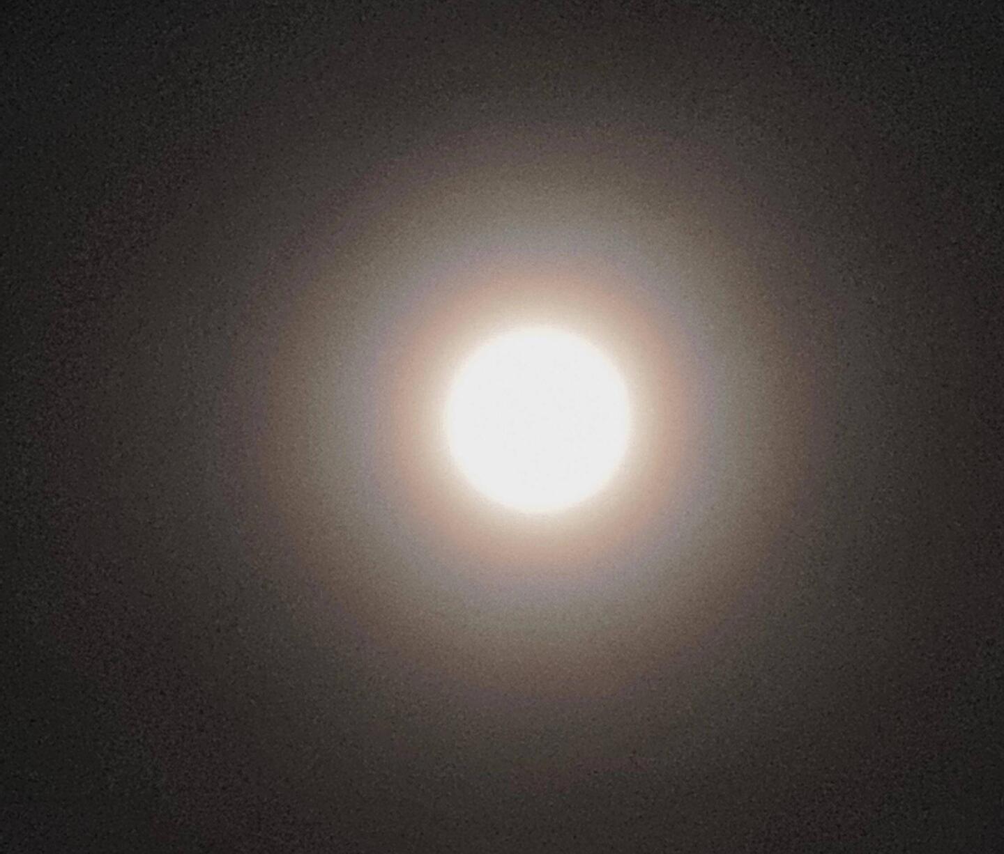 Riesengroßer Vollmond mit Regenbogenhof