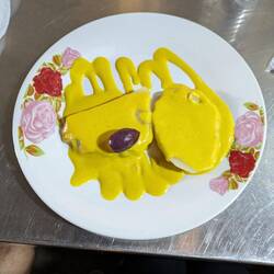 Die Vorspeise: zwei Scheiben Kartoffel mit gelber Soße