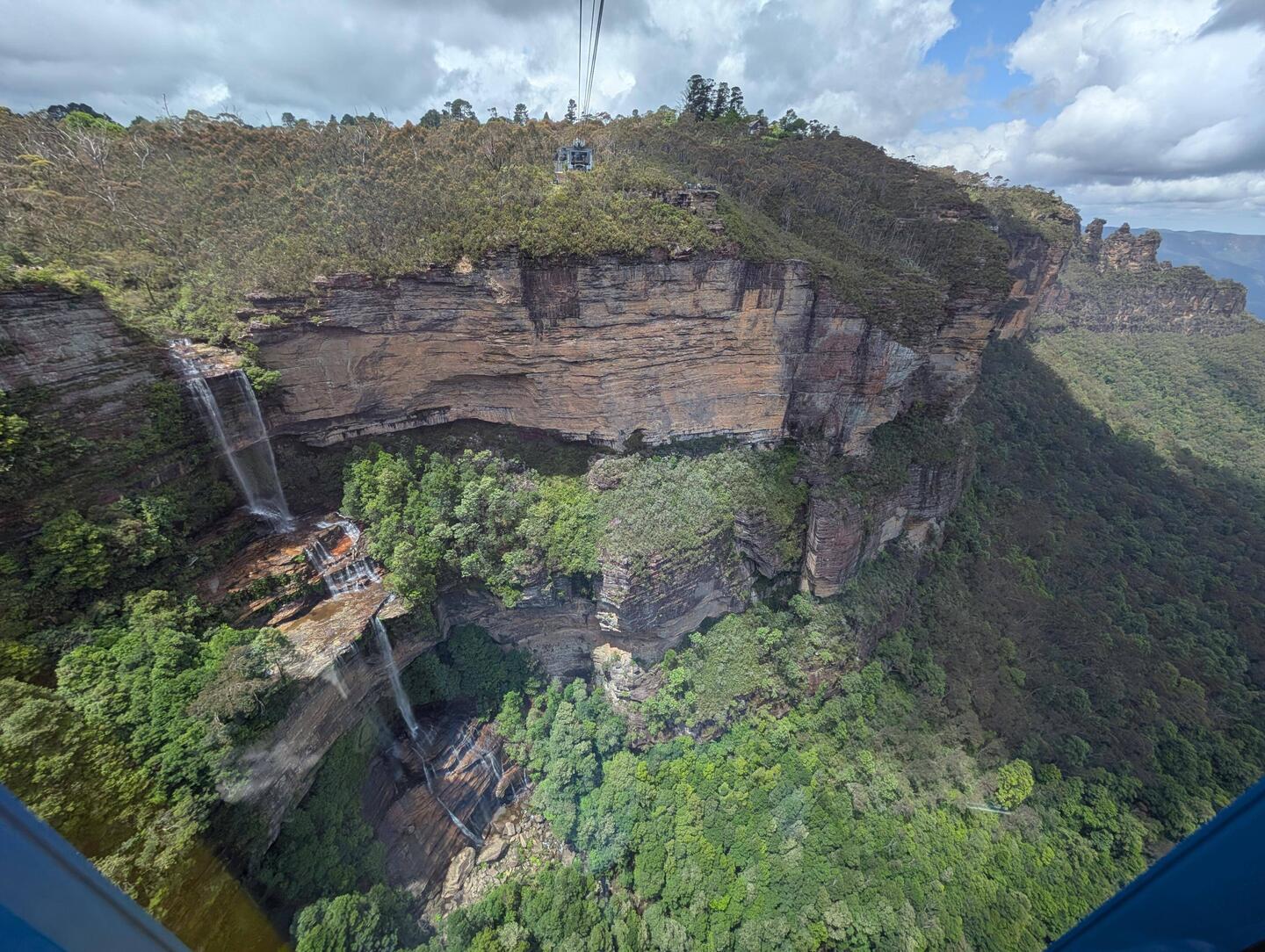 Katoomba falls to the left , 3 sisters on the right from the cable car